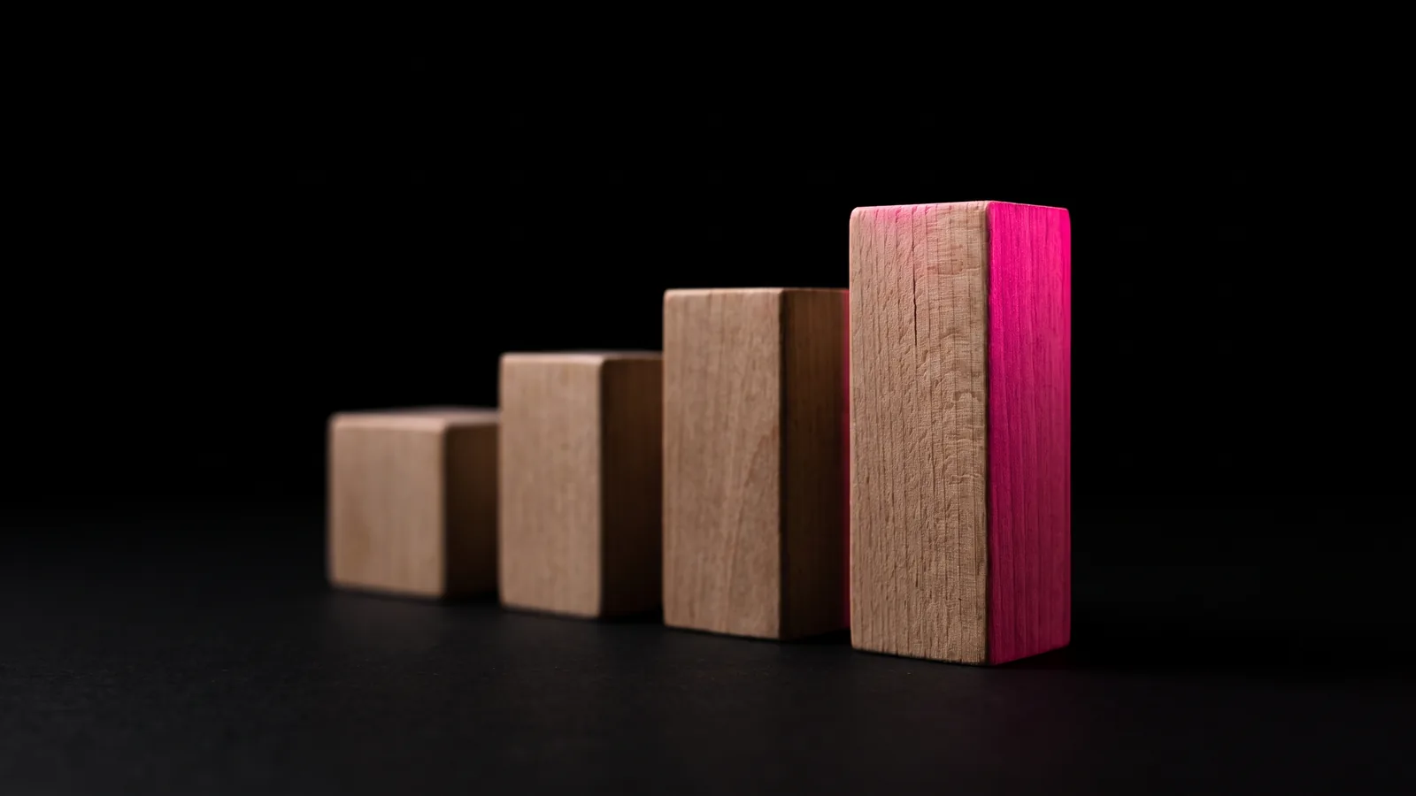 Four blank wooden blocks of rising height on black with the tallest edge lit hot pink, four ways to pay an AI consultant