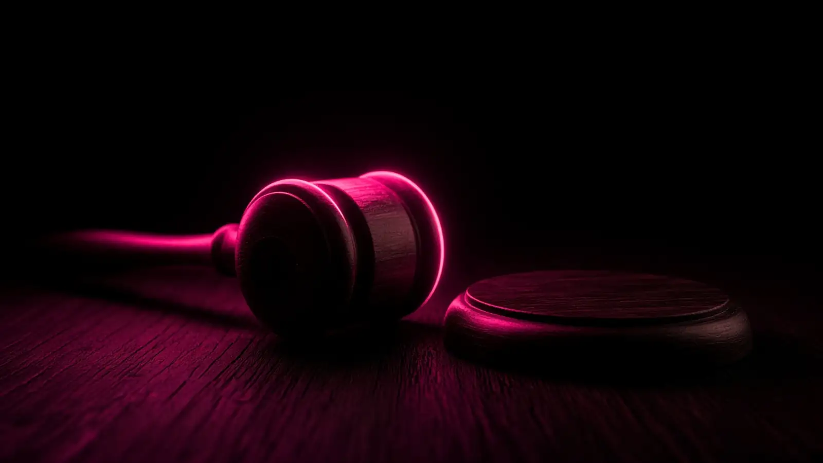 A gavel resting on a dark wooden surface with a hot pink rim light, Chapter 93A technology vendor disputes in Massachusetts