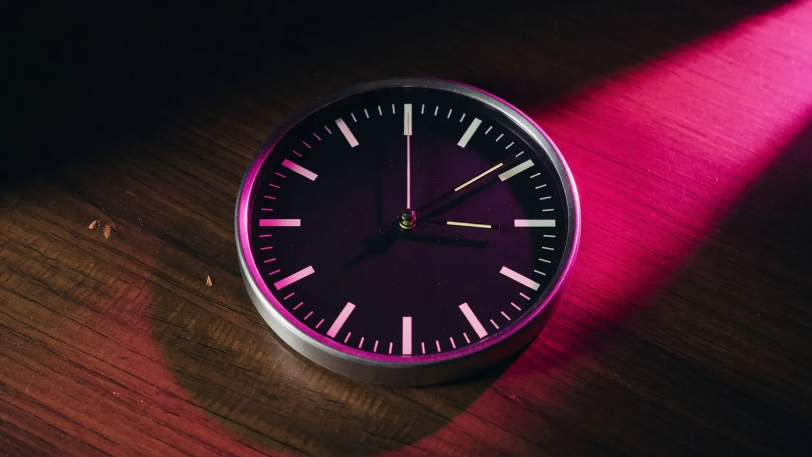 A magenta clock on a dark desk, business continuity restore drill