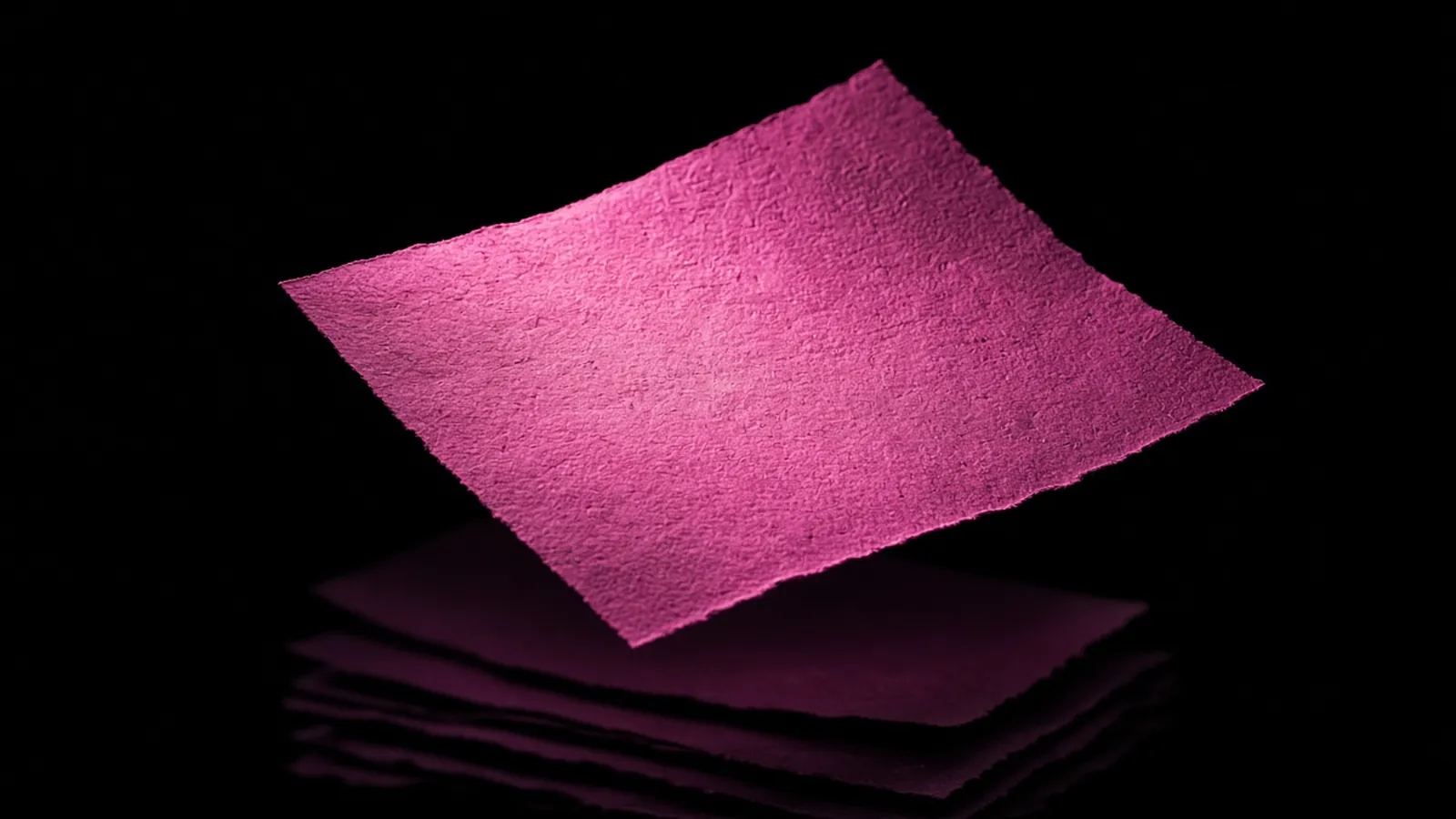 One magenta document lit above dim duplicates on black, evidence supporting a cyber insurance renewal application