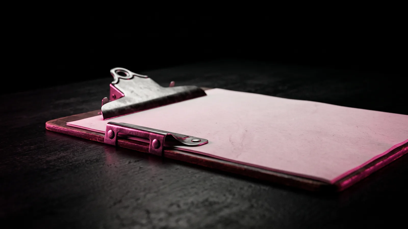 A blank invoice sheet clipped to a metal clipboard on a black desk, edge-lit hot pink, the vendor bill where quishing reaches accounts payable