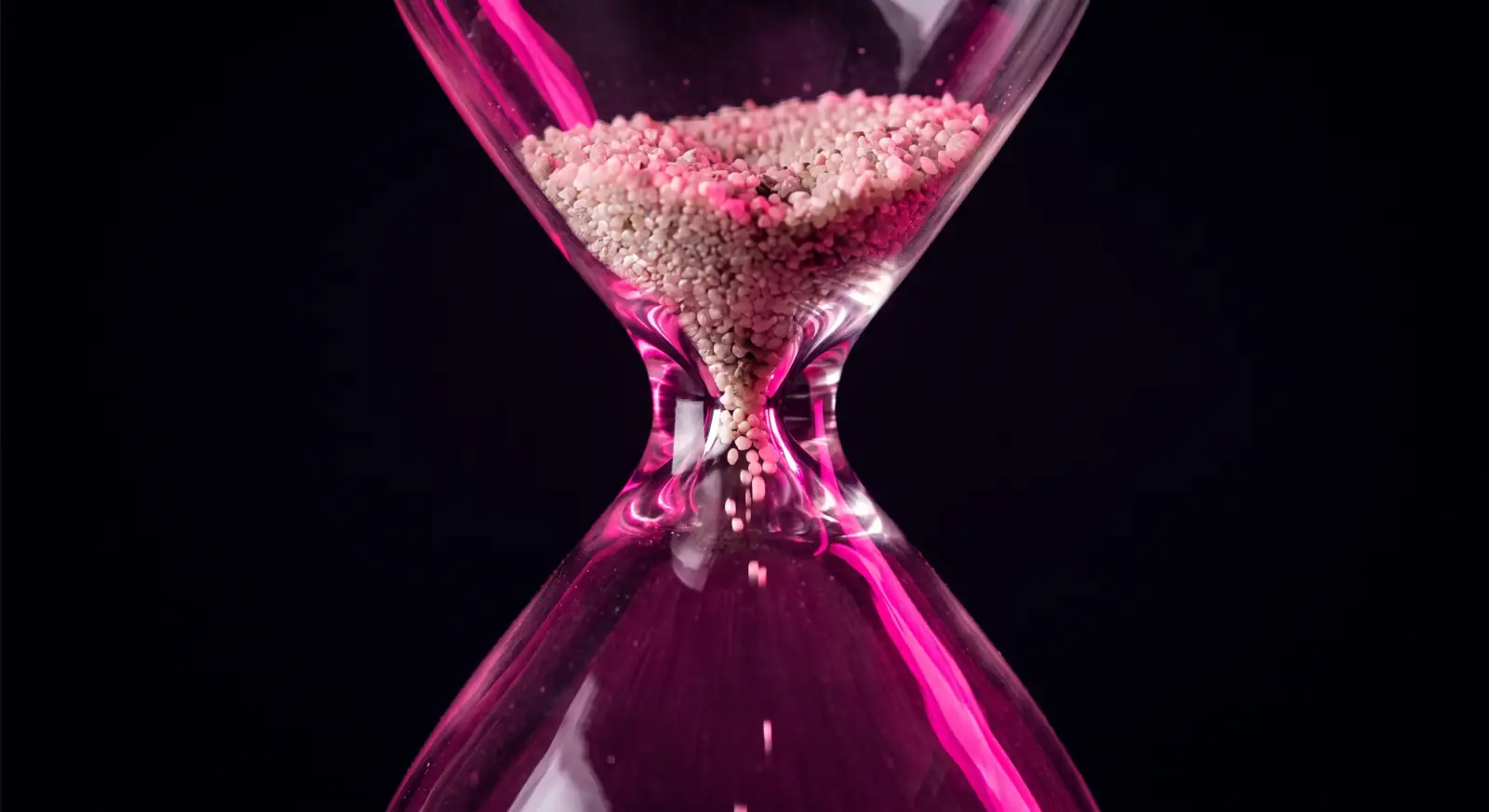 An hourglass with sand jammed at the neck, illustrating the theory of constraints